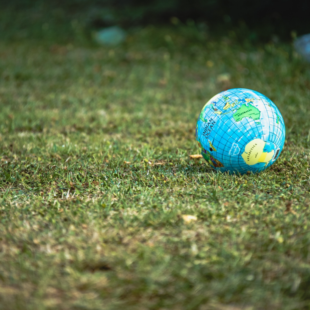 Bilde av en lekeball formet som en jordklode, stående på en gressplen