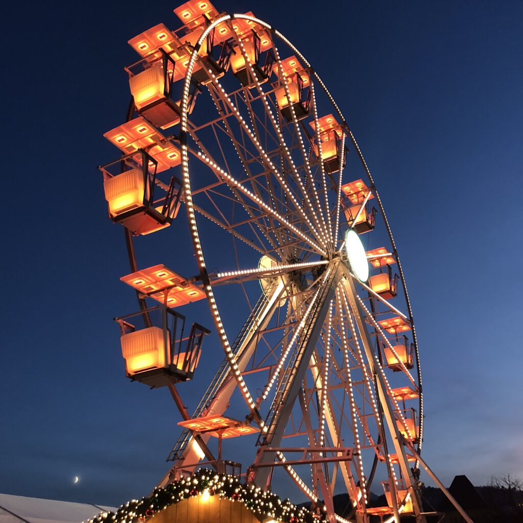 Bilde av pariserhjulet på Bergen Julemarked. Det er mørkt og masse julelys.