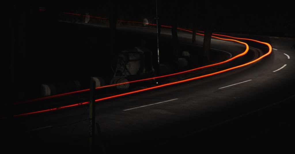 Bilde av en bilvei i mørket, med lystråd over kjørefelt